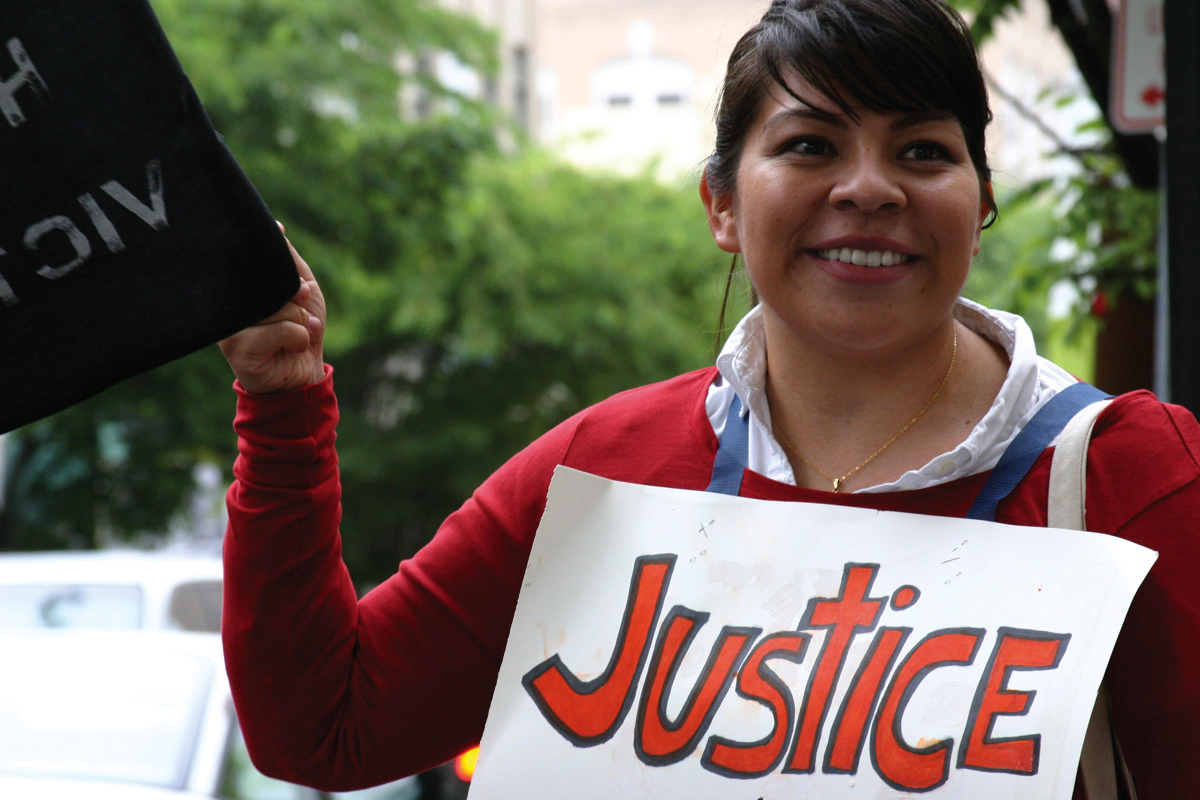 A young woman holding a saign that says justice A young woman holding a saign that says justice