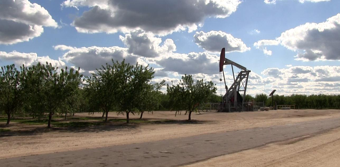 An oil well near an almond farm in Shafter CA An oil well near an almond farm in Shafter CA