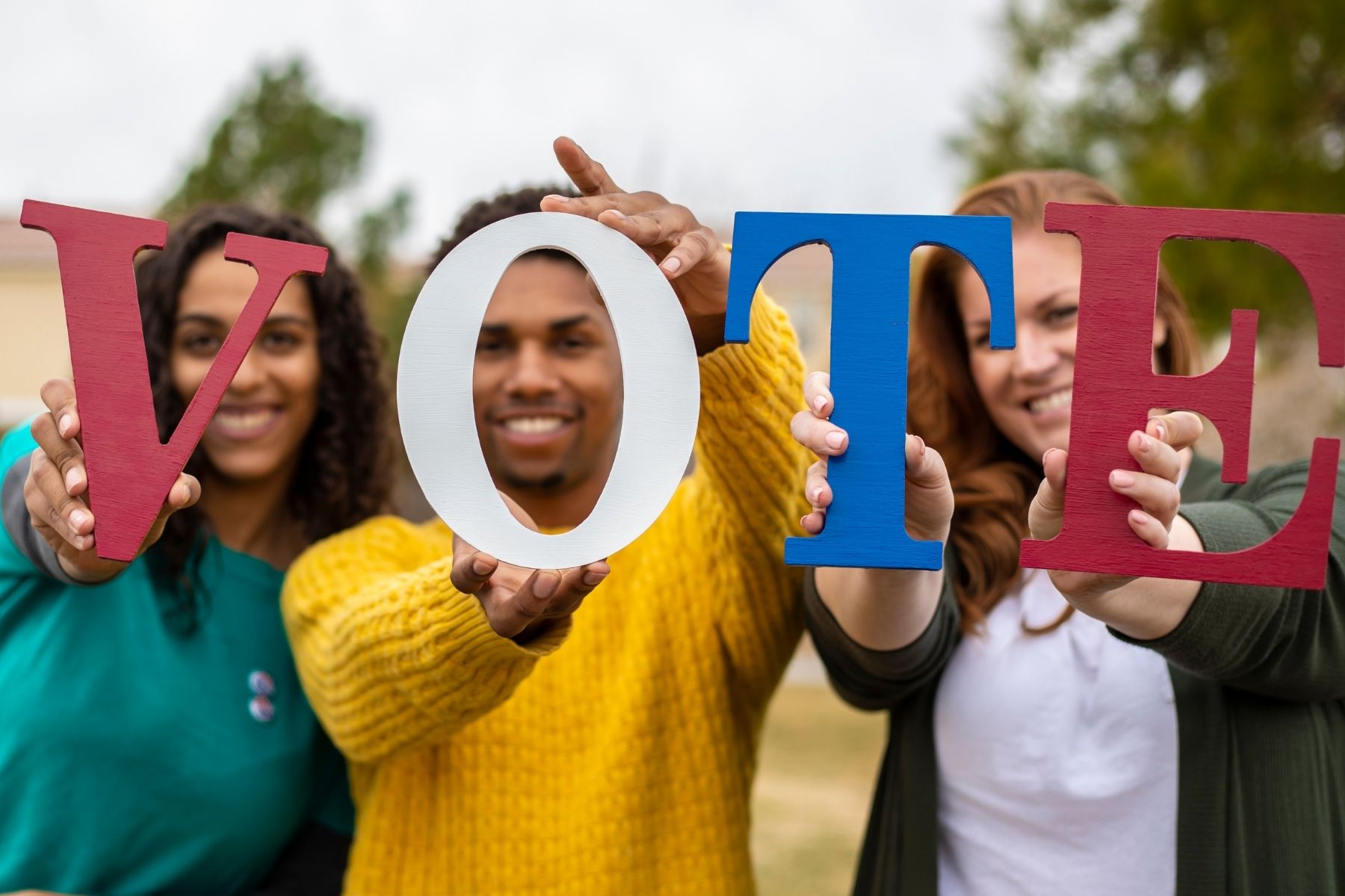 Elections_Vote-Canva.jpg People hold letters that spell vote.