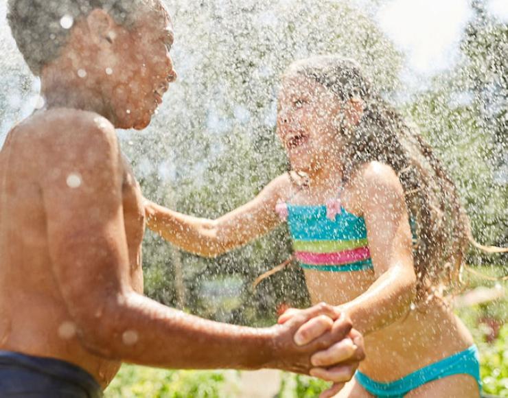 Kids splashing in water and nature.