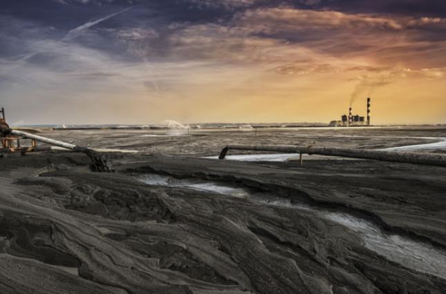 Acres of coal ash with a plant in the background Acres of coal ash with a plant in the background