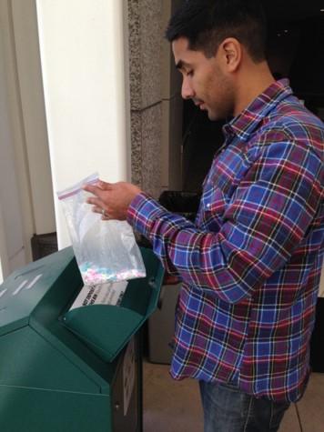 A person properly disposing of medications at a drug disposal drop box A person properly disposing of medications at a drug disposal drop box